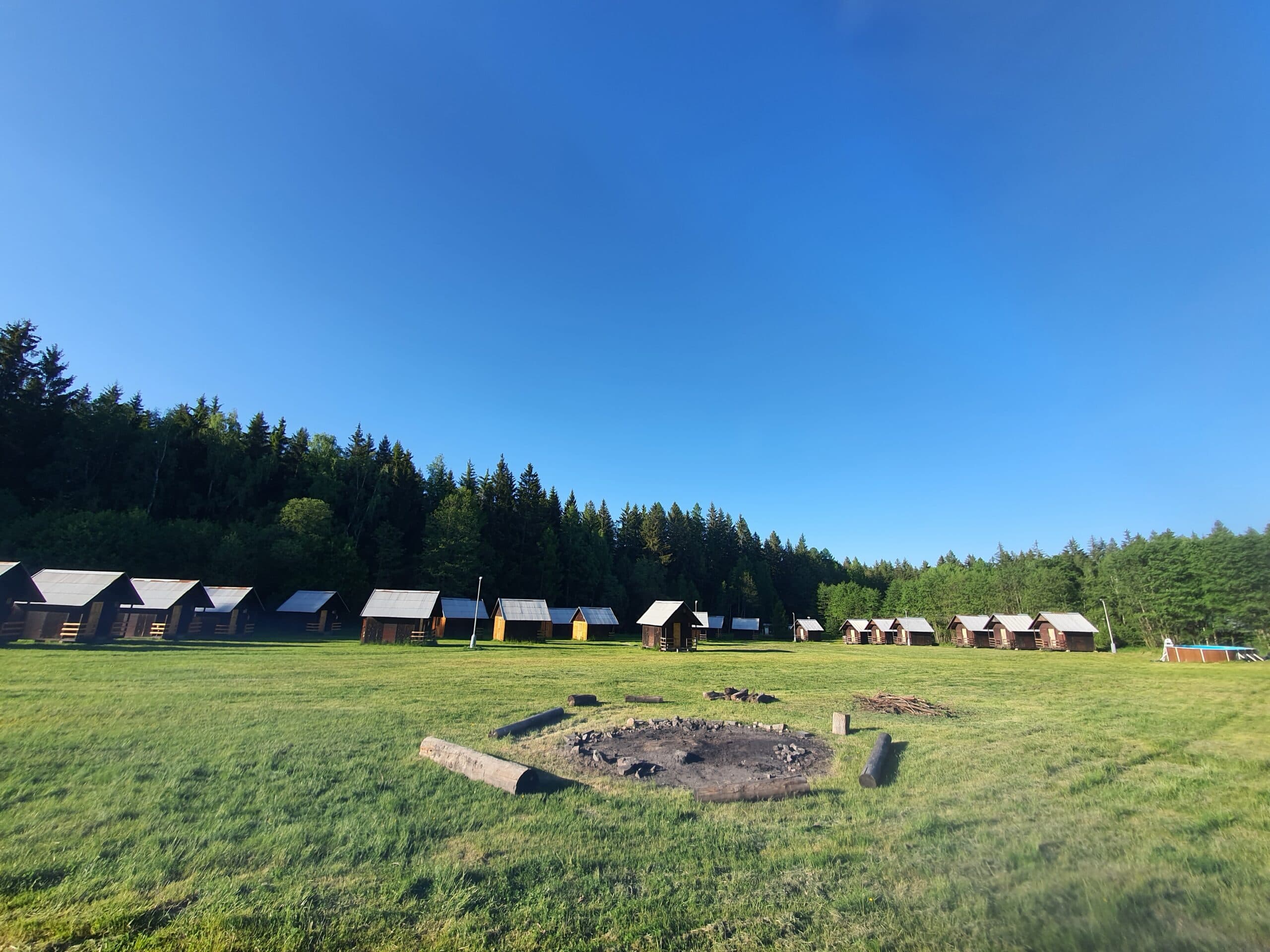 Dřevěné chatičky a ohniště v areálu resortu