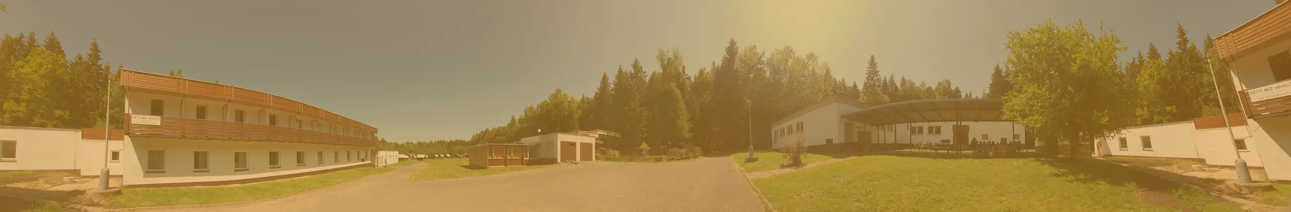 Panoramatický pohled na penzion, louku a chatičky