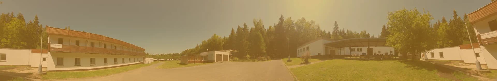 Panoramatický pohled na penzion, louku a chatičky